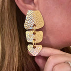 Jakris gold hammered metal drop earrings with modern chain link design worn on ear