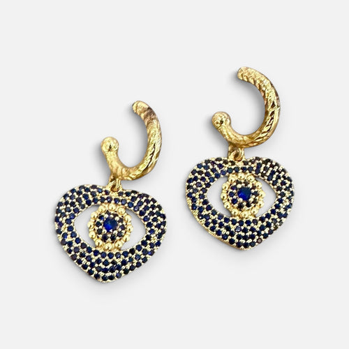 Jakris gold heart earrings featuring blue crystal evil eye details and textured hoop closures