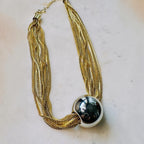 Jakris gold-tone multi-strand chain necklace featuring a large polished spherical ball pendant