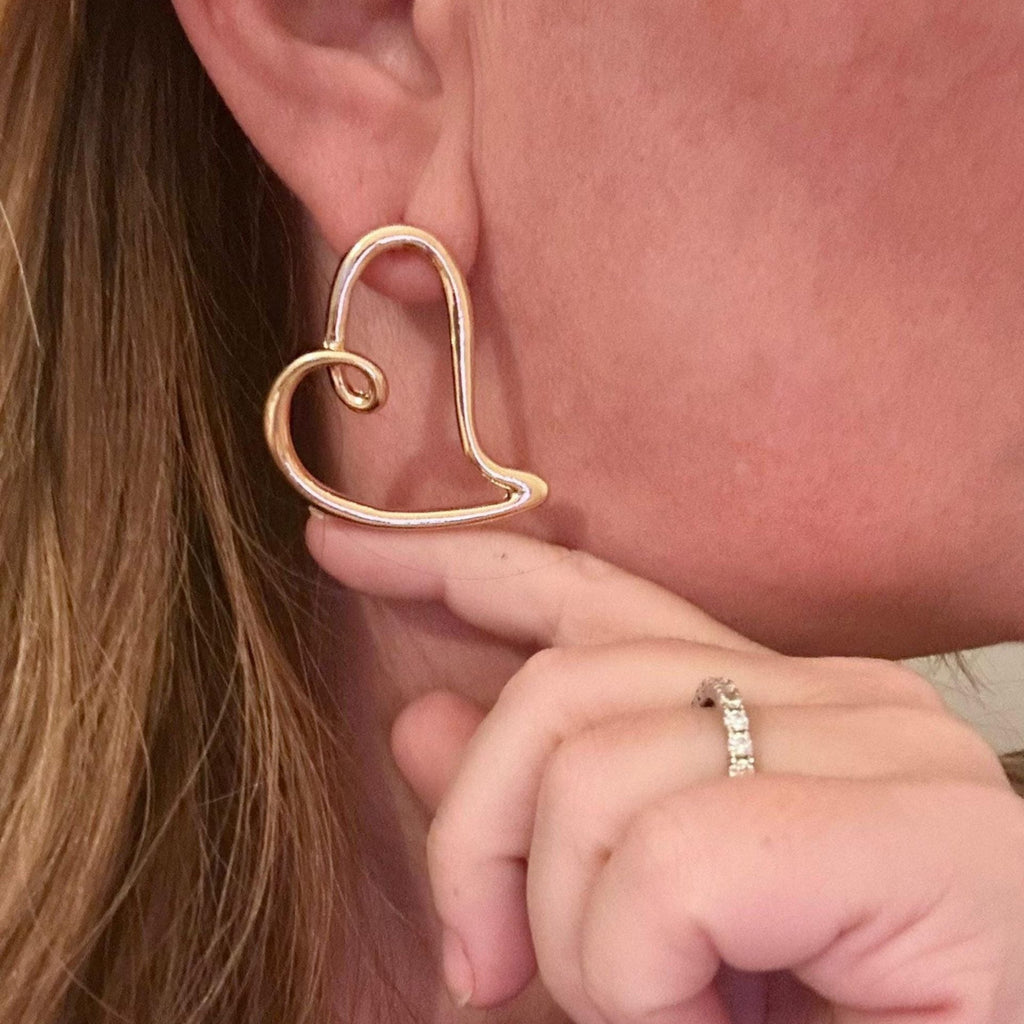 Jakris gold open heart earring with a minimal and elegant design worn on a woman's ear