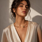 Jakris gold-plated brass open hoop choker necklace with asymmetrical polished sphere ends worn by a woman.