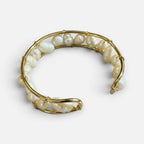 Jakris gold cuff bracelet featuring natural freshwater pearls in an open, elegant, and modern design.