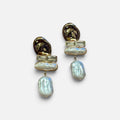 Jakris gold-toned dangling earrings featuring modern geometric metal accents and lustrous baroque pearls