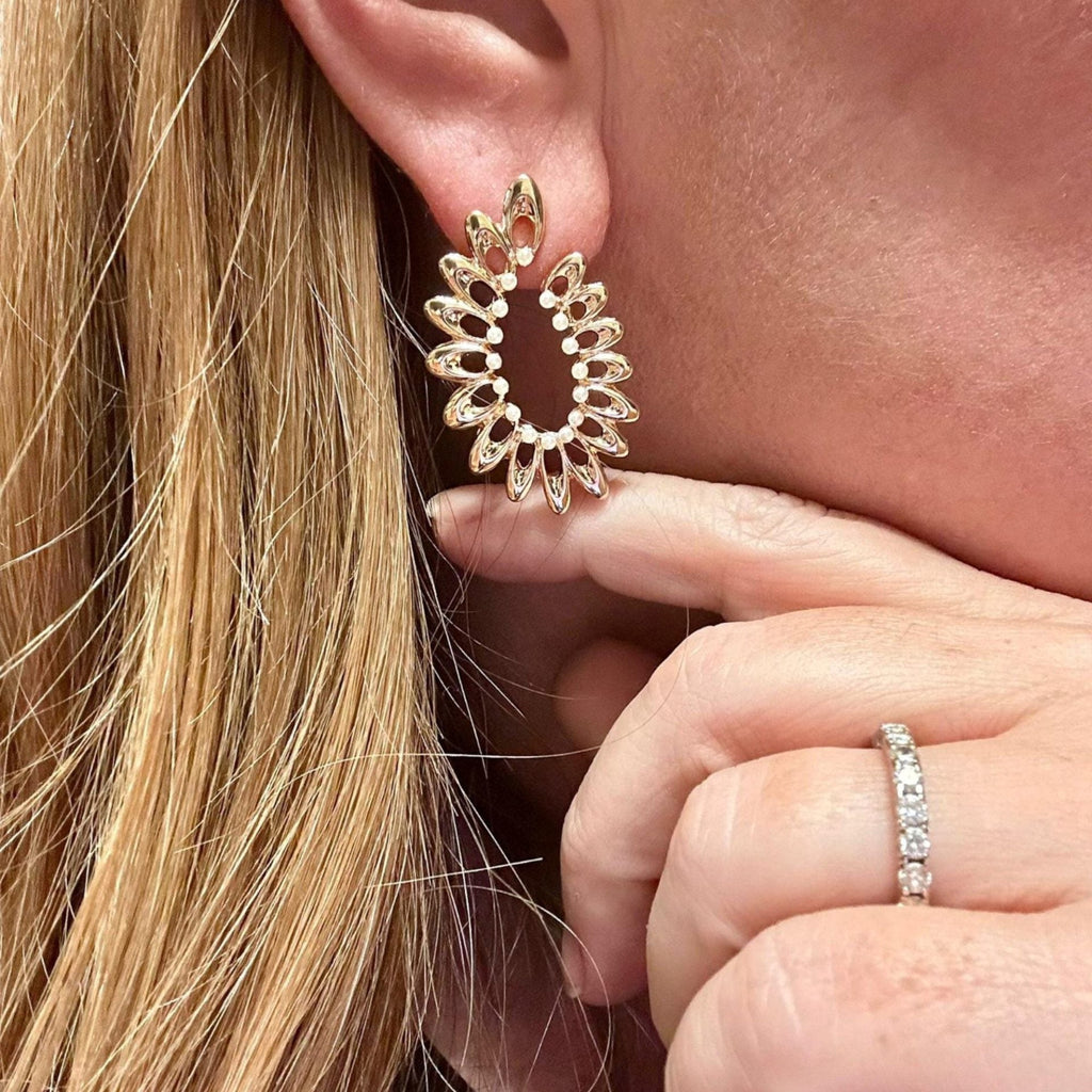 Jakris gold-plated fan-shaped hoop earrings with delicate pearl accents worn on a model