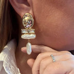 Jakris gold-tone statement earring featuring a textured metal disc, crystal bar, and dangling baroque pearls