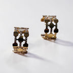 Jakris gold-plated hoop earrings featuring a thick, geometric dotted pattern on a clean white background.