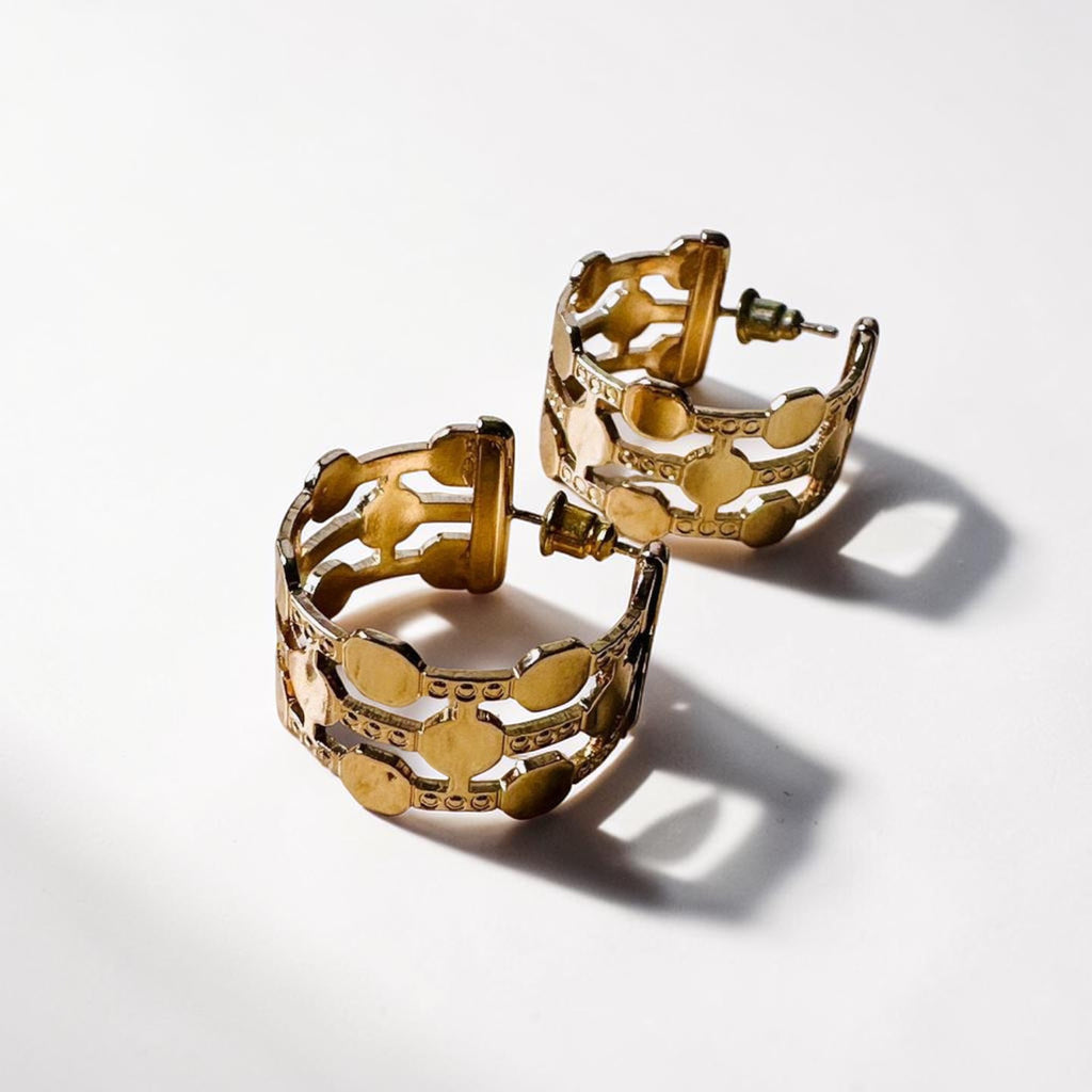 Jakris gold-plated hoop earrings featuring a thick, intricate dotted pattern on a white background.