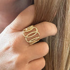 Jakris gold-plated adjustable spiral ring with a sculptural open design worn on a finger