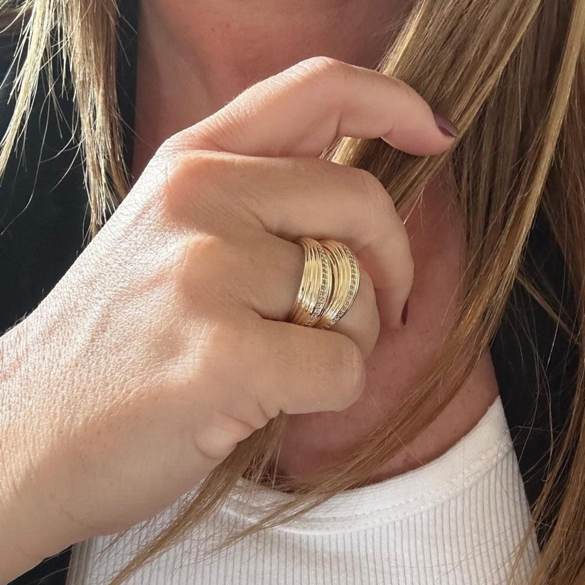 Jakris gold-plated adjustable ring with a textured multi-band design worn on a woman's finger