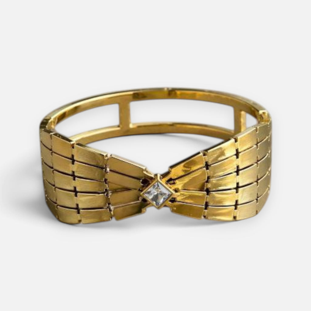 Jakris gold-toned retro cuff bracelet featuring a geometric bow design with a central square-cut crystal stone.