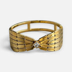 Jakris gold-toned retro cuff bracelet featuring a geometric bow design with a central square-cut crystal stone.
