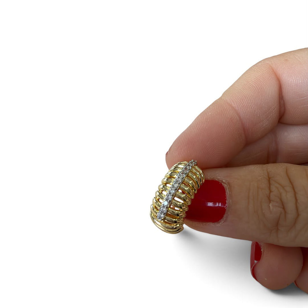 Jakris gold-tone ear cuff with a ribbed cage design and a central row of clear crystals held by a hand