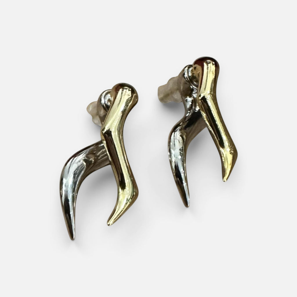 Jakris modern abstract earrings featuring a two-tone gold and silver metallic design with a sleek, curved shape.