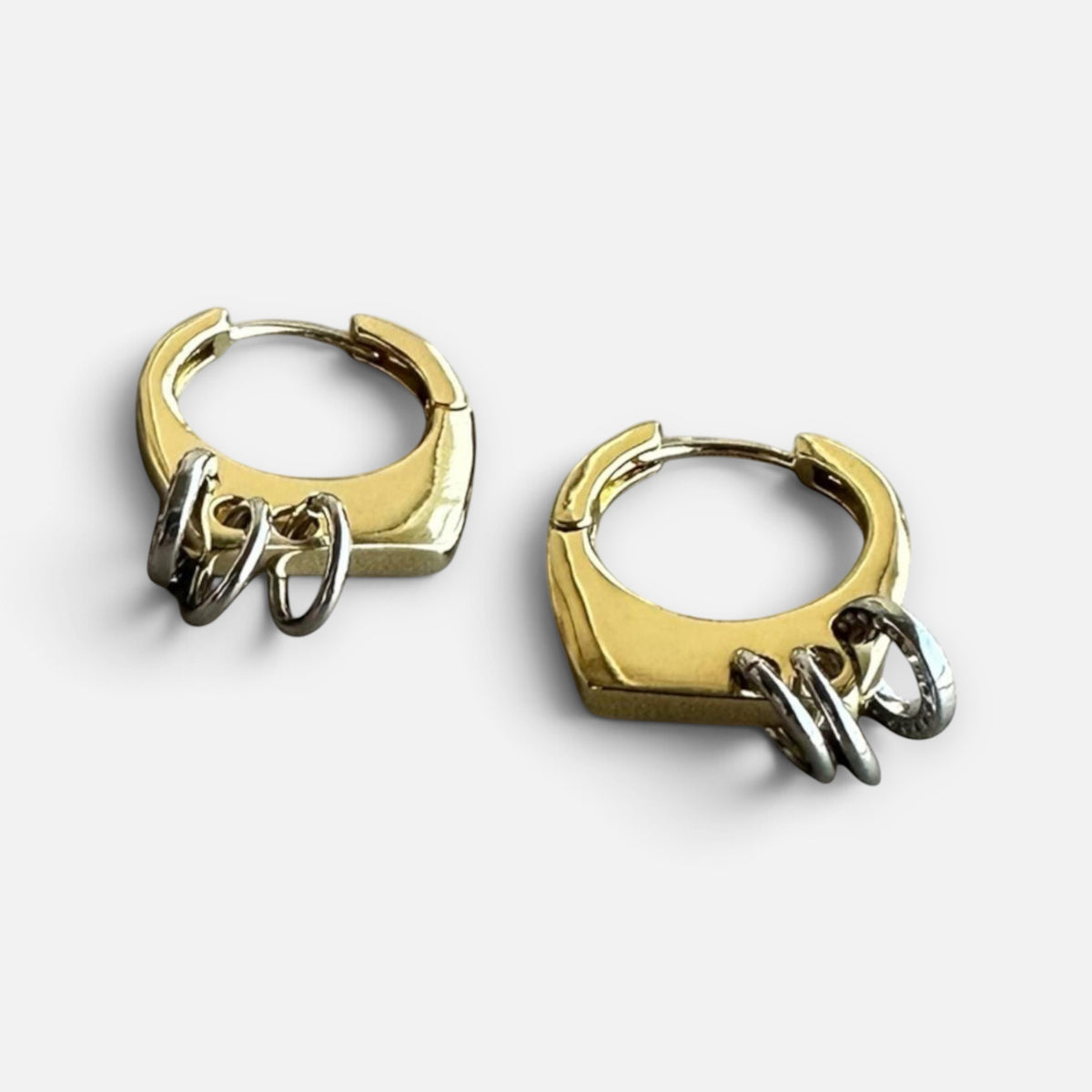 Jakris modern gold-tone hoop earrings featuring small silver-tone ring charms in a geometric design