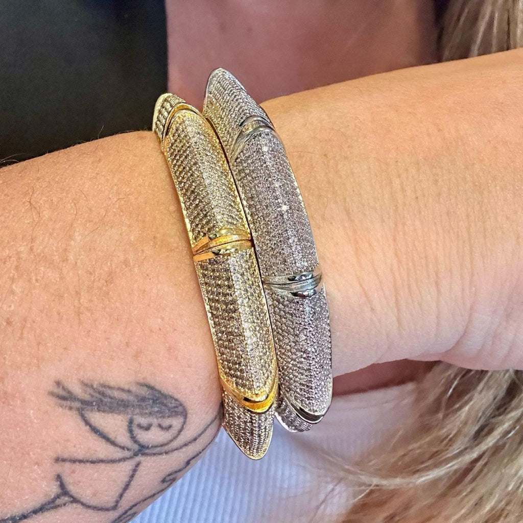 Jakris gold and silver tone cuff bracelets featuring sparkling zircon stones worn on a wrist