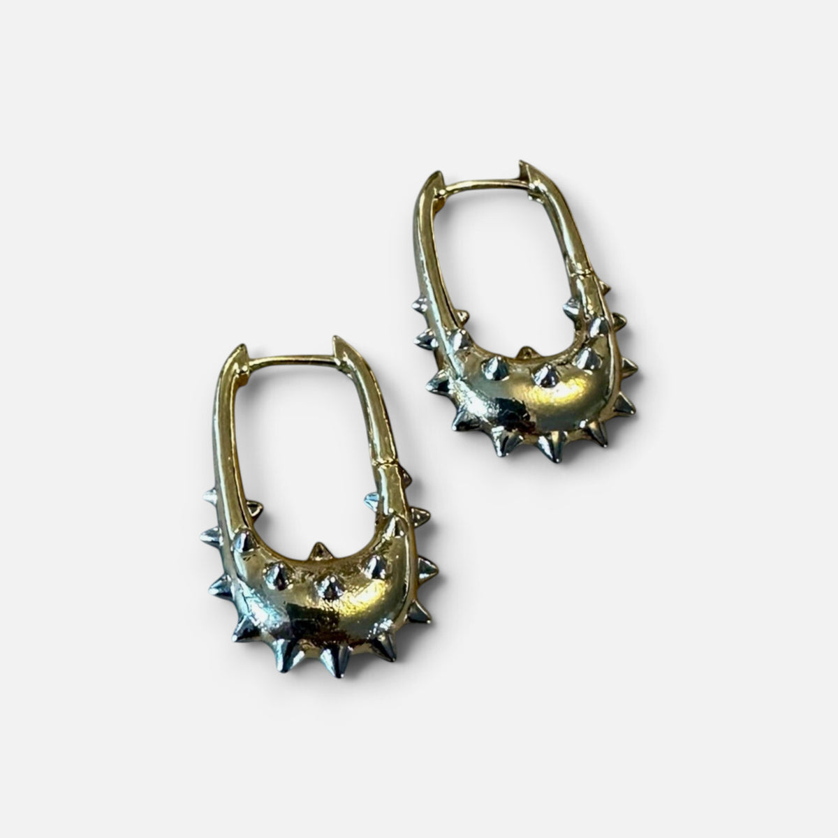 Jakris gold hoop earrings featuring a unique U-shape design with edgy silver-toned metal spikes.