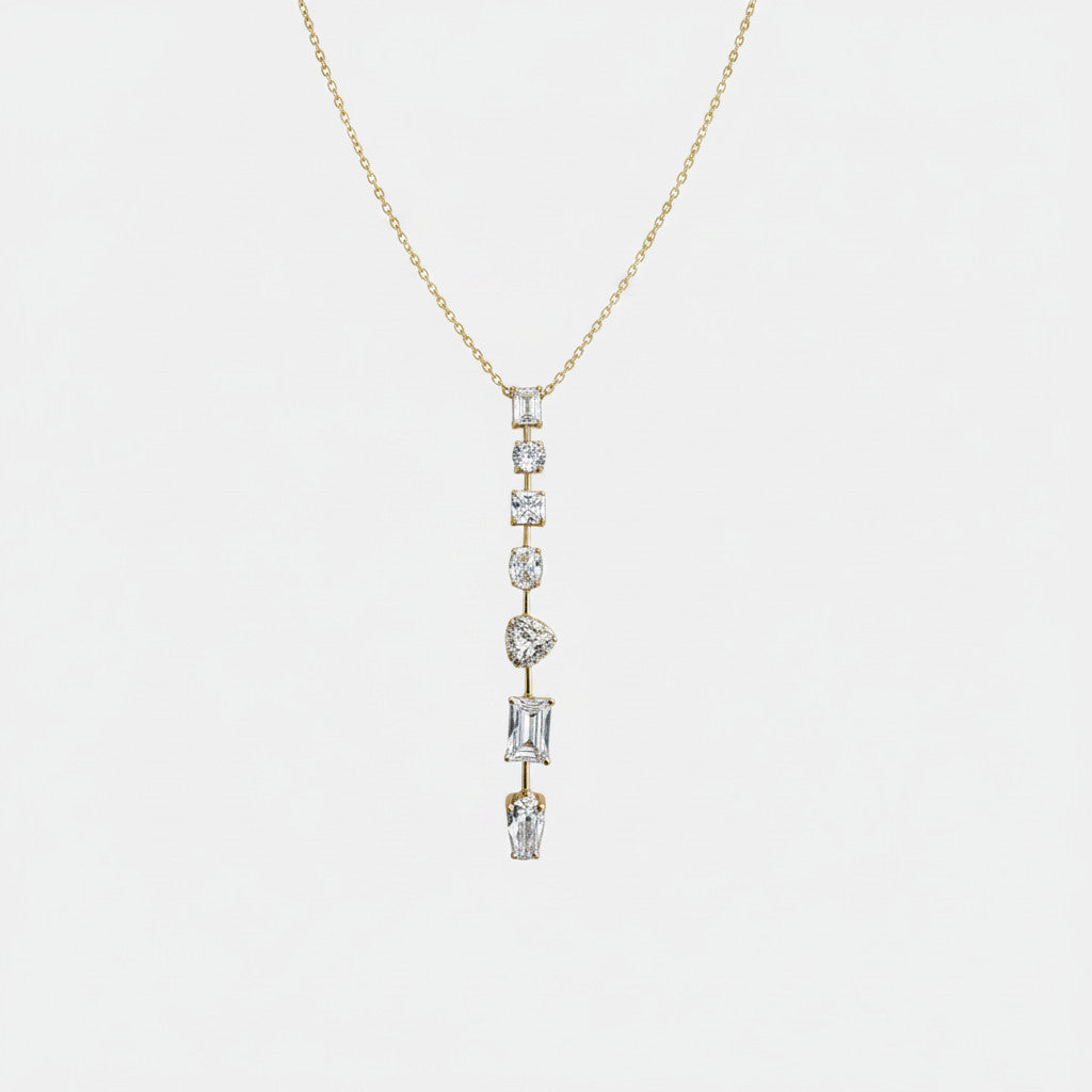 Jakris gold necklace featuring a vertical drop design with various shaped clear stones on a delicate chain