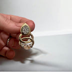 Jakris gold teardrop earrings featuring sparkling pavé stones and circular accents held in a hand