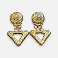 Jakris gold triangle drop earrings with textured geometric surfaces and central pearl accents