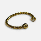 Jakris gold twisted cuff bracelet featuring a delicate pearl accent at the open end