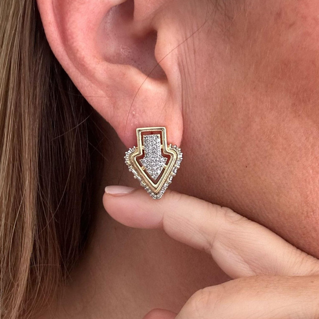 Jakris gold-plated Art Deco arrow stud earring featuring sparkling zircon stones worn on a model's earlobe
