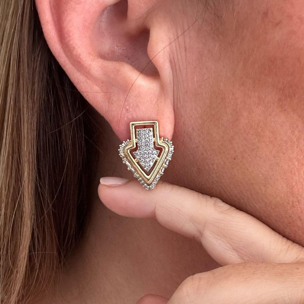 Jakris gold-plated Art Deco arrow stud earring featuring sparkling zircon stones worn on a model's earlobe
