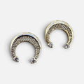 Jakris gold crescent moon earrings adorned with sparkling zircon stones on a reflective surface.