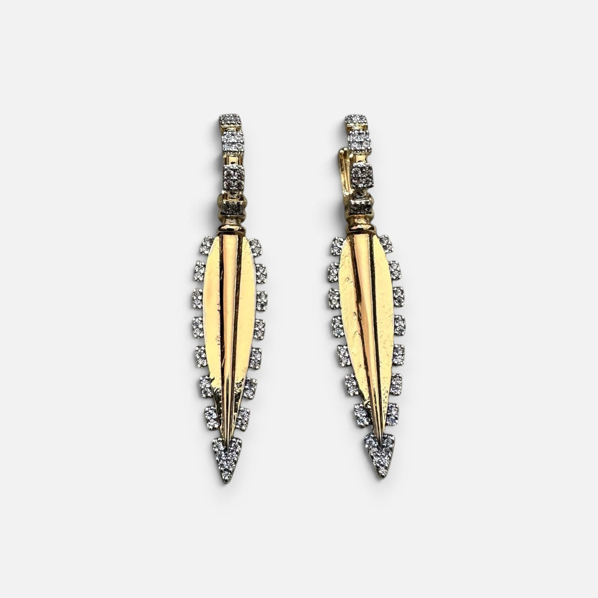 Jakris gold-plated long drop earrings featuring intricate zircon stone detailing on a white display stand.
