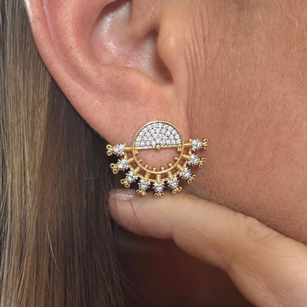 Jakris gold fan-shaped earring featuring sparkling zircon crystals and delicate tassel details worn on an earlobe