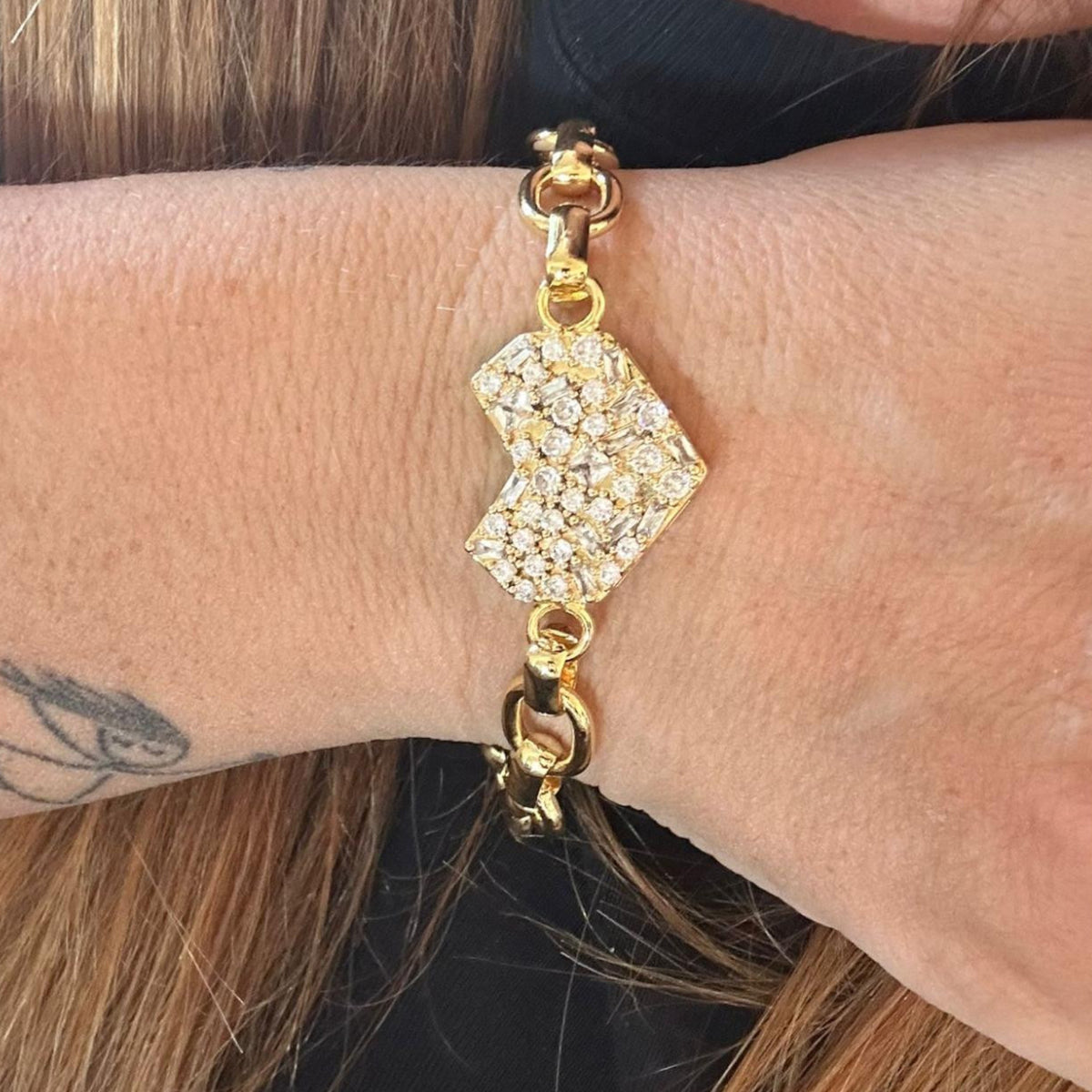 Jakris gold chain bracelet featuring a large heart-shaped pendant encrusted with sparkling zircon crystals