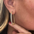 Jakris gold hoop earring with twisted texture and sparkling zircon stones worn on a woman's ear
