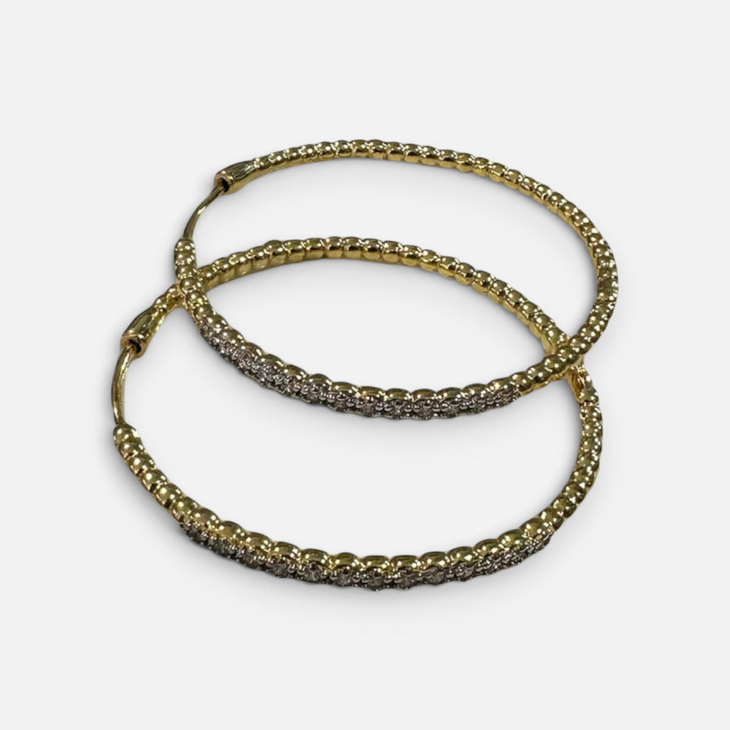 Jakris gold hoop earrings featuring a twisted design and sparkling zircon stone accents for an elegant look