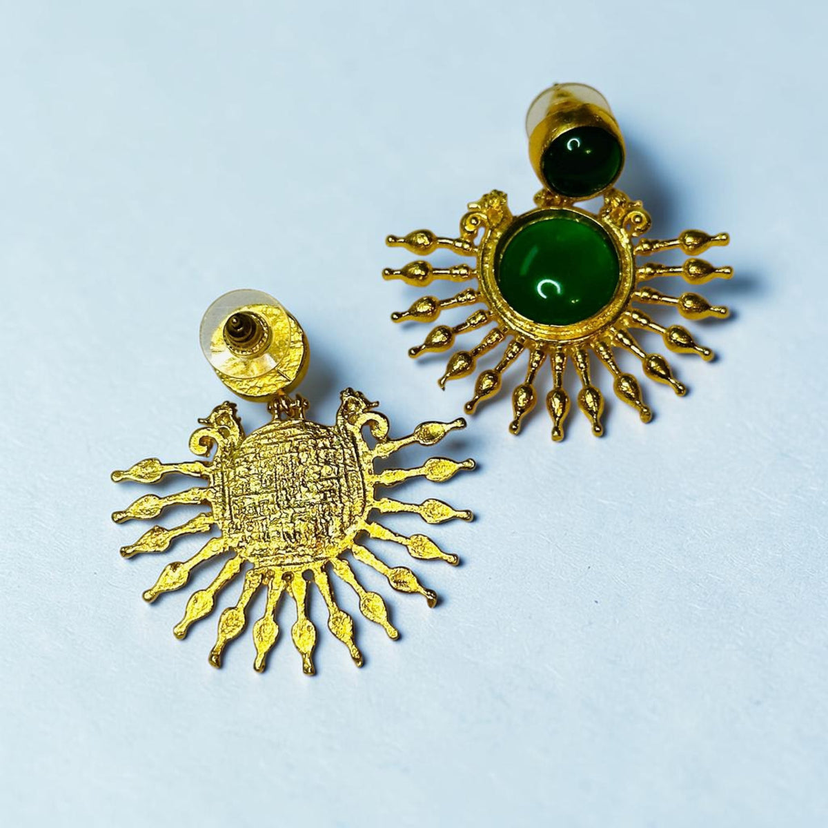 Jakris gold-plated sun-shaped drop earrings featuring green onyx stones on a white background.
