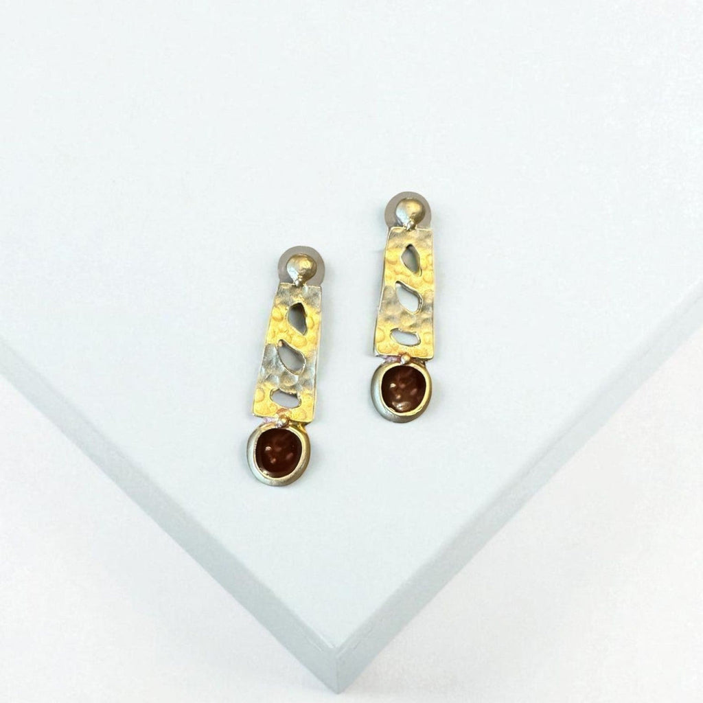 Jakris designer earrings featuring hammered gold-tone metal, cut-out geometric shapes, and brown stone accents.