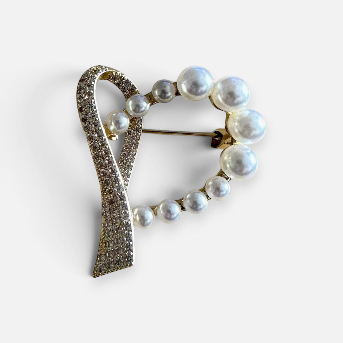 Jakris heart-shaped brooch featuring lustrous white pearls and sparkling gold-tone crystals on a metallic frame.