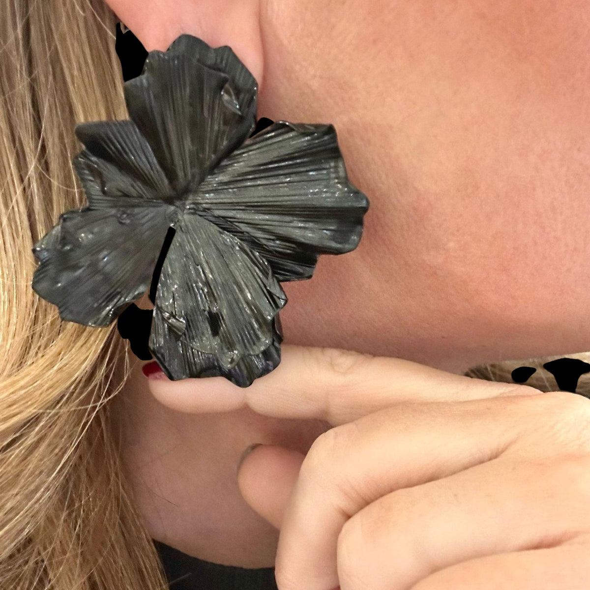 Jakris large black flower statement earring worn on ear with textured petal design