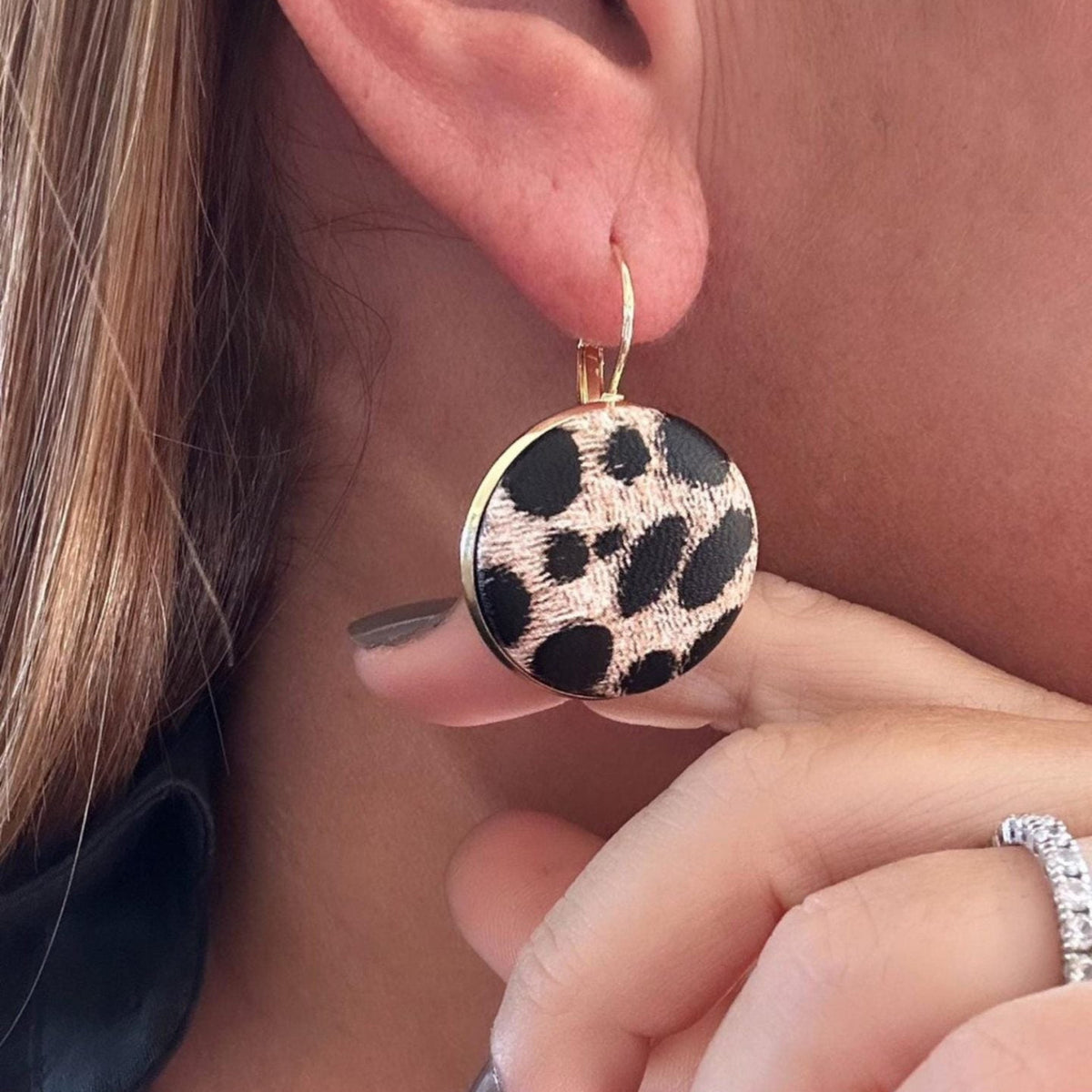 Jakris round dangle earrings featuring a black and beige leopard print pattern on a gold-tone metal frame
