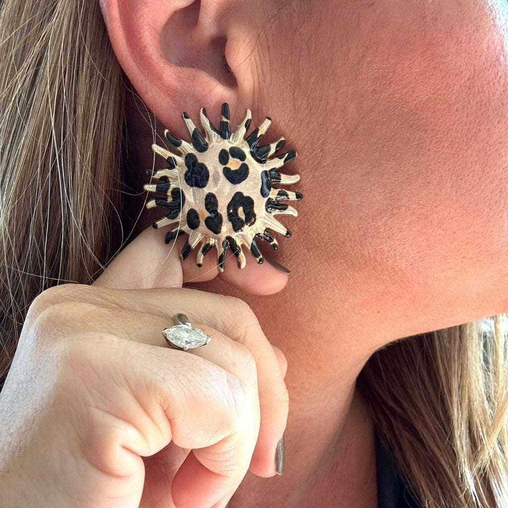 Jakris round statement earring with leopard and zebra print and a serrated edge worn on a woman's ear