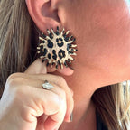 Jakris round statement earring with leopard and zebra print and a serrated edge worn on a woman's ear