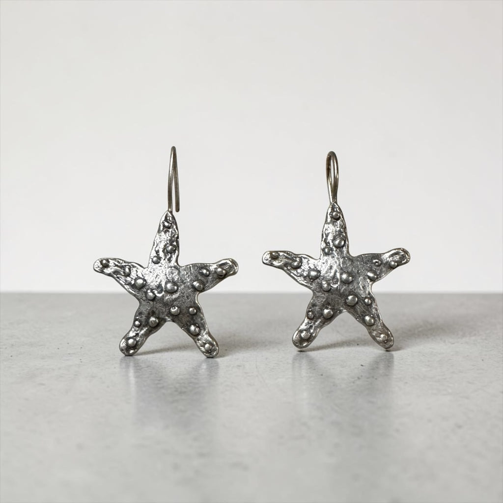 Jakris Maris silver-plated brass starfish earrings with a textured surface and minimalist hook design.