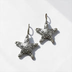 Jakris Maris silver-plated brass starfish earrings with a textured surface on a white background