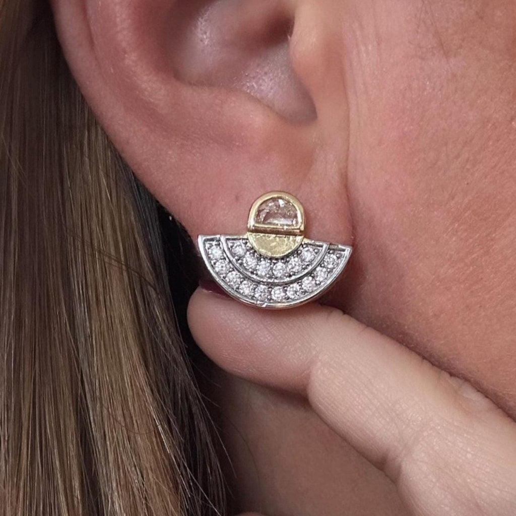 Jakris minimal fan-shaped stud earring featuring sparkling crystals and a gold-tone accent worn on an earlobe