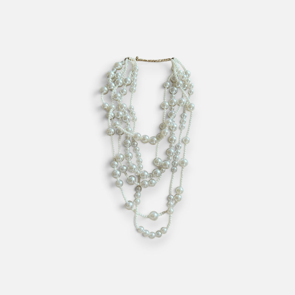 Jakris multi-strand long pearl necklace featuring layered white beads for a bridal or elegant formal look.