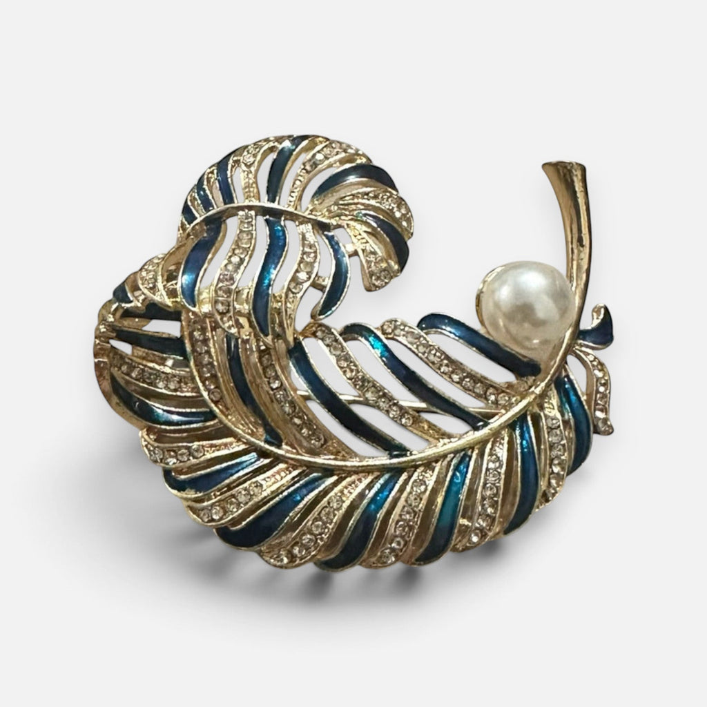 Jakris navy blue enamel feather brooch with gold-tone metal, sparkling crystals, and a central white pearl accent.