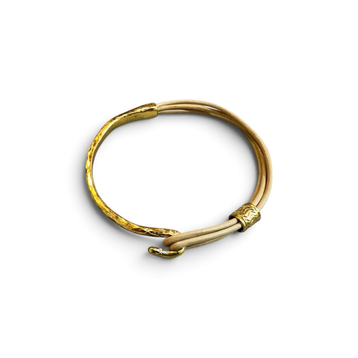 Jakris Nia deri ince bileklik, bej deri kordon ve dövme altın rengi metal detaylara sahip minimalist tasarım.