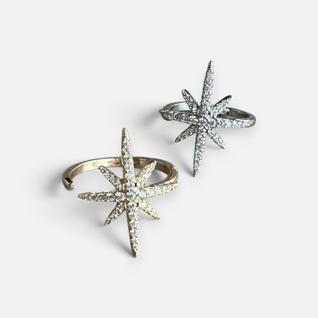 Jakris adjustable North Star rings in gold and silver tones with sparkling crystal accents on a white background.