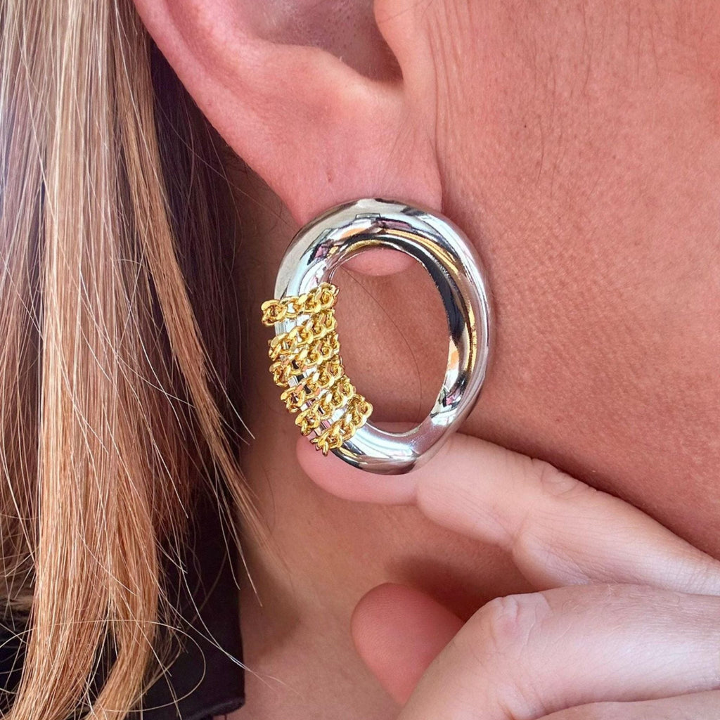 Jakris oval silver earring featuring a modern gold chain detail worn on an ear