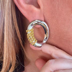 Jakris oval silver earring featuring a modern gold chain detail worn on an ear