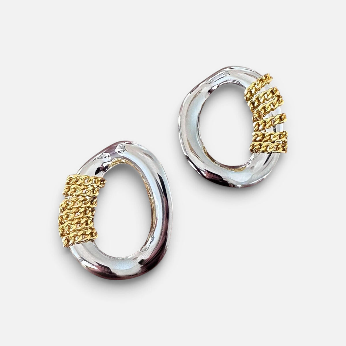 Jakris oval silver earrings featuring decorative gold-tone chain detailing for a modern two-tone look.