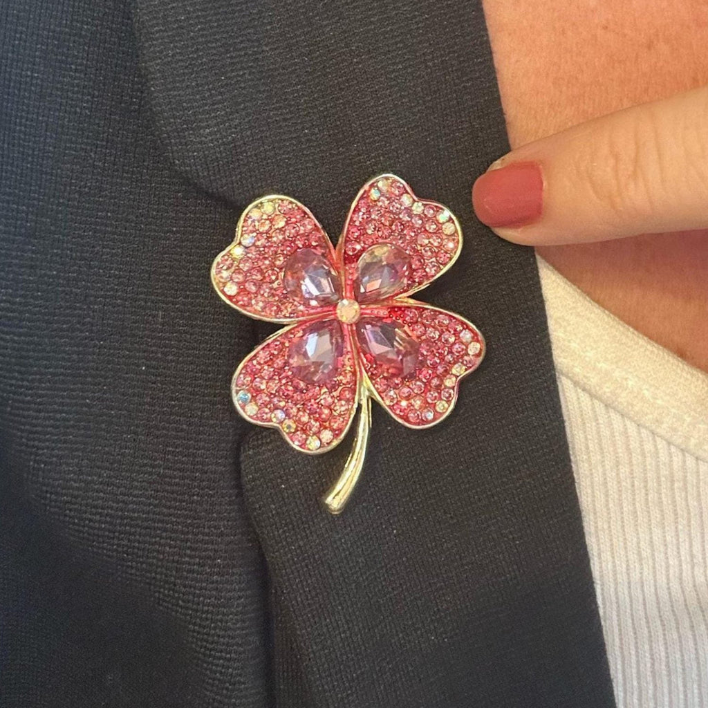 Jakris four-leaf clover brooch featuring pink crystals on a black blazer lapel